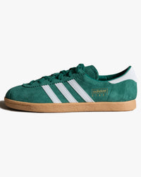 adidas stadt trainers green with white stripes from side against white background