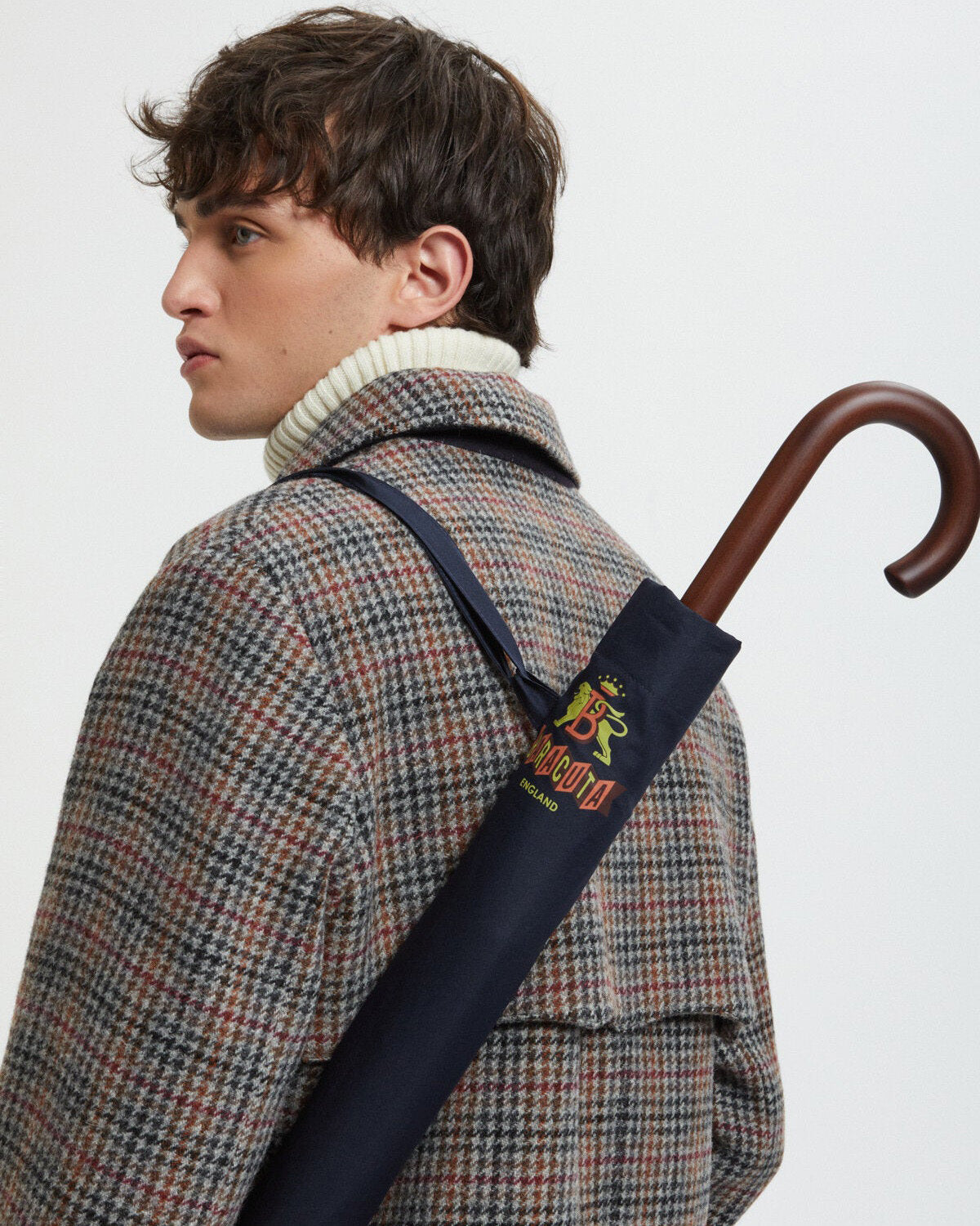 baracuta navy umbrella worn over shoulder with wooden handle detail