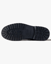 Close-up of black boot sole on side a white background
