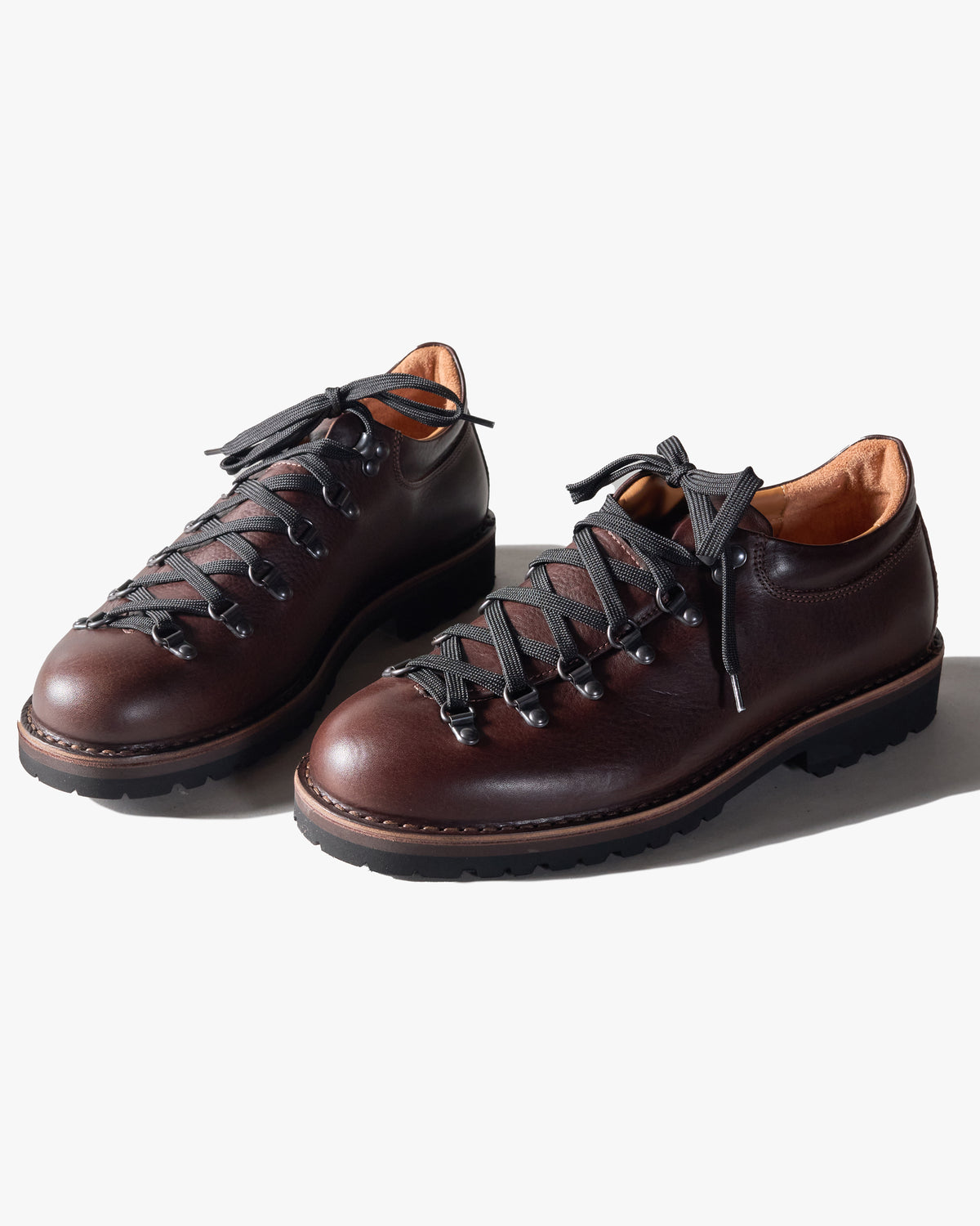 Pair of dark brown Fracap leather shoes with black laces on a white background