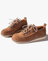 Pair of brown Fracap suede shoes with white laces on a light gray background