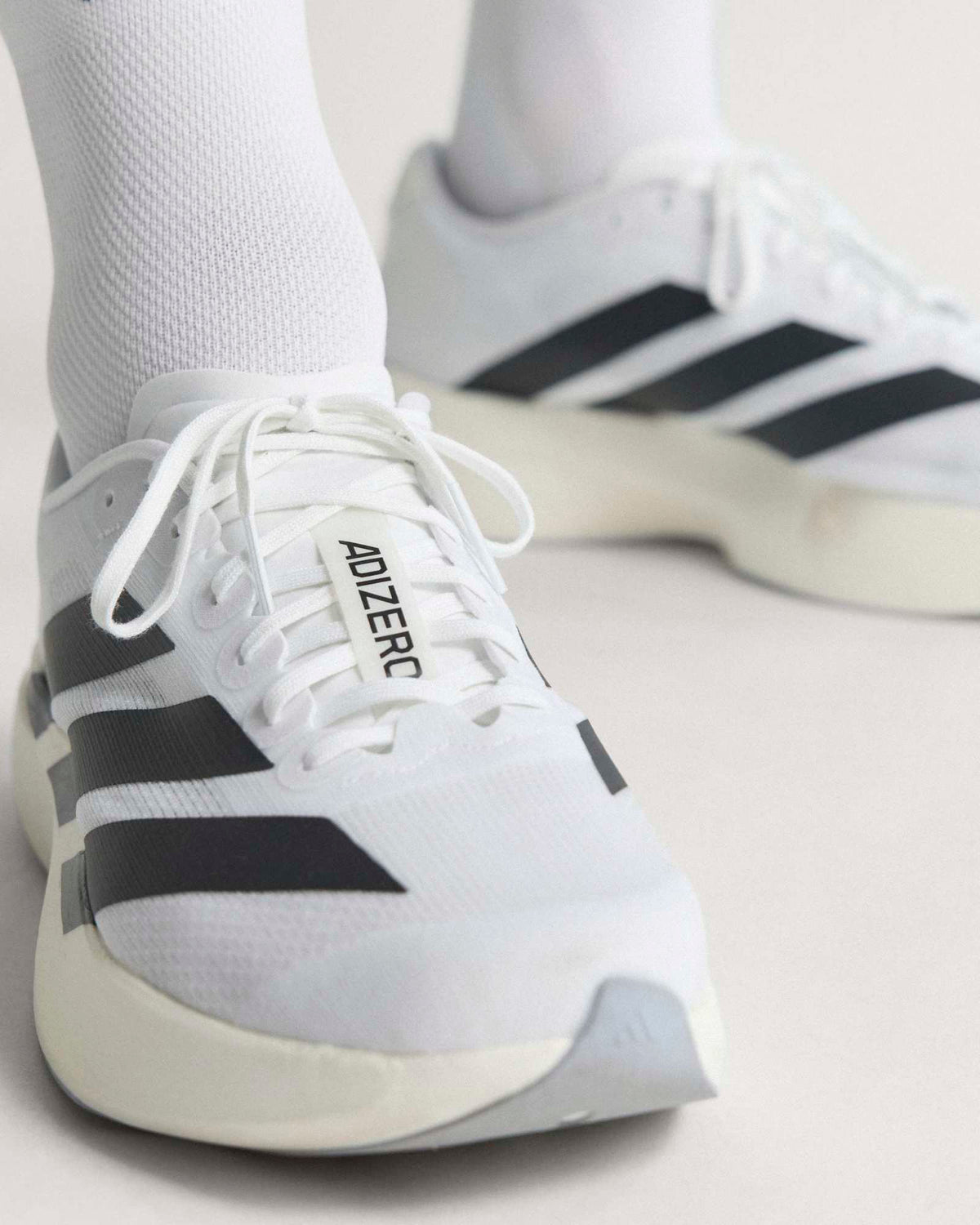 adidas adizero evo sl running shoes close up worn on model's feet