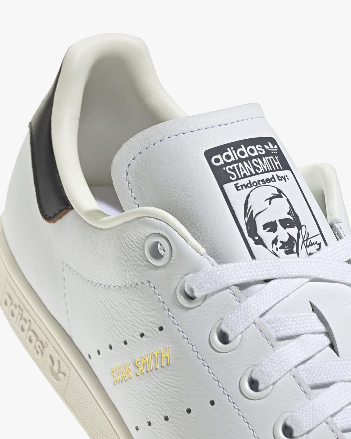 adidas stan smith trainers white leather upper and green heel tab detail close up
